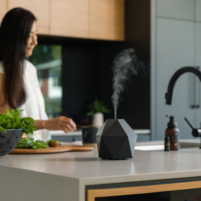 Black Aroma Be Free diffuser diffusing on a white kitchen counter