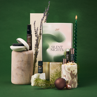 Silent Nights kit, including a mist, diffuser blend, lava rock diffuser, and 2 roll-ons, arranged among festive decor.