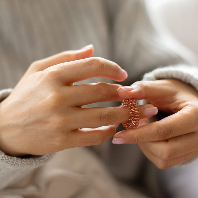 Relax-O-Ring gently and evenly being rolled up and down on a finger